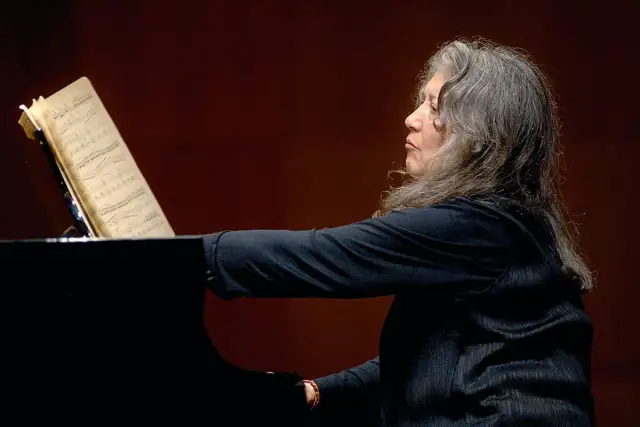Martha Argerich, pianistka o argentyńskim pochodzeniu, gra na fortepianie, wpatrzona w nuty.