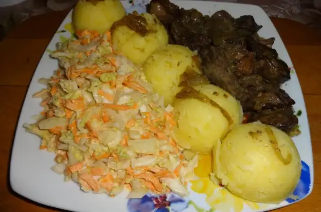 Talerz z wątróbką, ziemniakami i surówką z kapusty i marchewki.