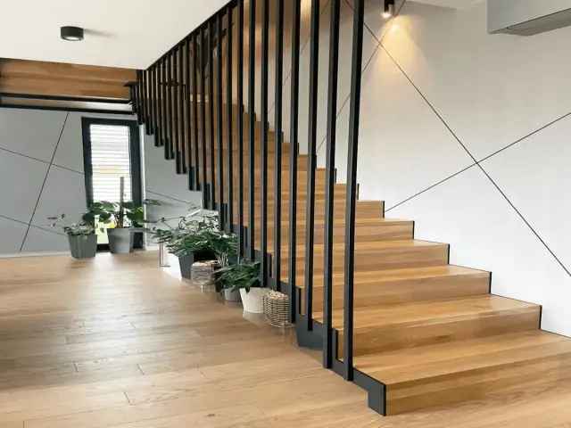 Nowoczesne schody na konstrukcji stalowej z drewnianymi stopniami. Zastanawiasz się, ile kosztują schody na konstrukcji stalowej?