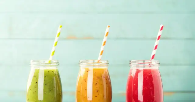 Trzy kolorowe koktajle w słoiczkach, idealne na dietę koktajlową. Zielony, pomarańczowy i czerwony napój z owoców.