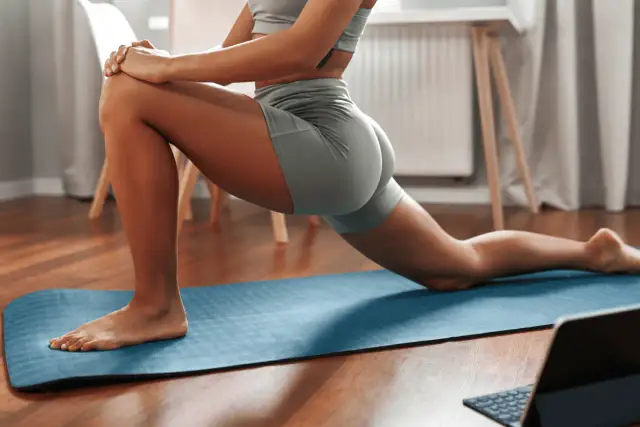 Kobieta ćwiczy na macie, zastanawiając się, ile minut dziennie ćwiczyć żeby schudnąć.