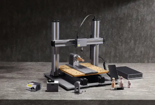 Drukarka 3D CNC z akcesoriami i wydrukowanymi figurkami.