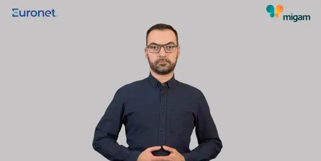 Mężczyzna w okularach i granatowej koszuli, z dłońmi złożonymi na brzuchu. Widoczne logo Euronet i Migam. Proces euronet rejestracja id.