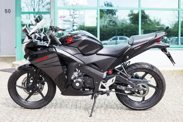 Czarny motocykl Honda CBR 125R z automatyczną skrzynią biegów, gotowy do jazdy po mieście.