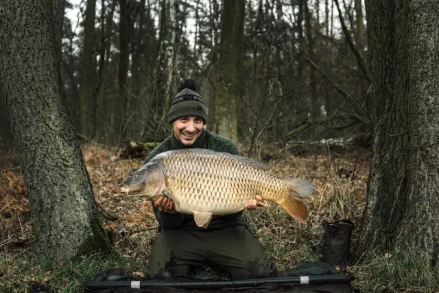 Szczęśliwy wędkarz z okazałym karpiem, złowionym gdzieś w lesie, może właśnie na łowisku Maślanka.