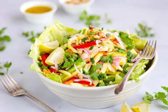 Kolorowa tajska sałatka z mango z Kuchennych Rewolucji, pełna świeżych ziół, orzeszków ziemnych i pikantnej papryczki.