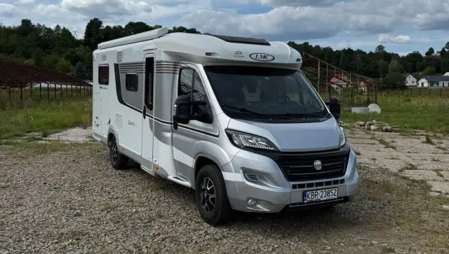 Nowy kamper 4 osobowy LMC, gotowy na wakacyjne przygody. Biało-srebrny, z wygodnym wnętrzem.