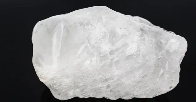 Surowy, biały ałun, minerał o krystalicznej strukturze, wygląda jak zamarznięta bryła lodu.