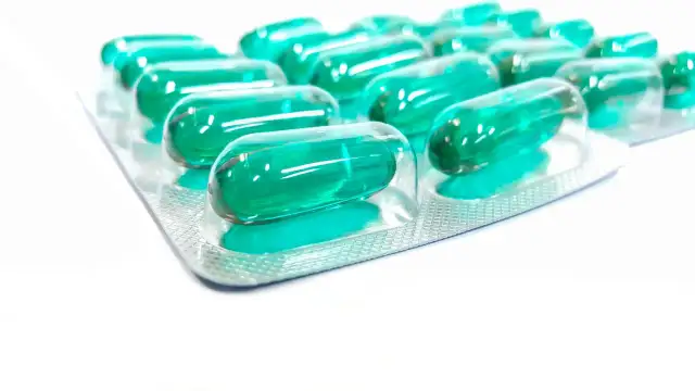 Blister opakowania z zielonymi kapsułkami. Pamiętaj o prawidłowym ibuprofen dawkowanie, by skutecznie złagodzić ból.