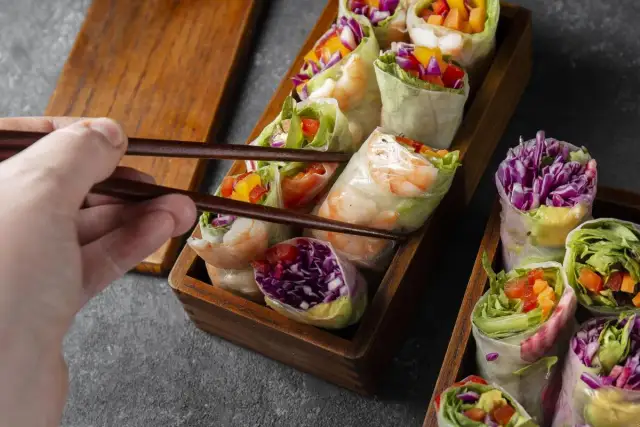 Chwytam pałeczkami świeże sajgonki z krewetkami, czerwoną kapustą i warzywami. Idealne co do sushi!