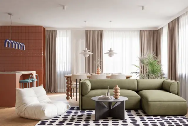 Nowoczesne mieszkanie w stylu PRL: zielona kanapa, puf, pomarańczowa ściana i okrągły stolik.