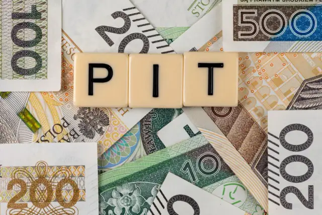 Litery "PIT" na tle polskich banknotów. Może oznaczać dużą niedopłatę podatku, która wymaga uzupełnienia.