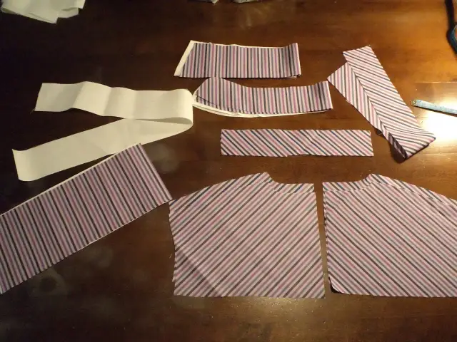 Kawałki materiału w paski, gotowe do szycia. Zastanawiasz się, jak poszerzyć bluzkę koszulową? Te elementy to pierwszy krok do stworzenia nowej kreacji.