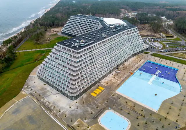 Widok z lotu ptaka na nowoczesny hotel Gołębiewski w Pobierowie z basenem i morzem w tle.