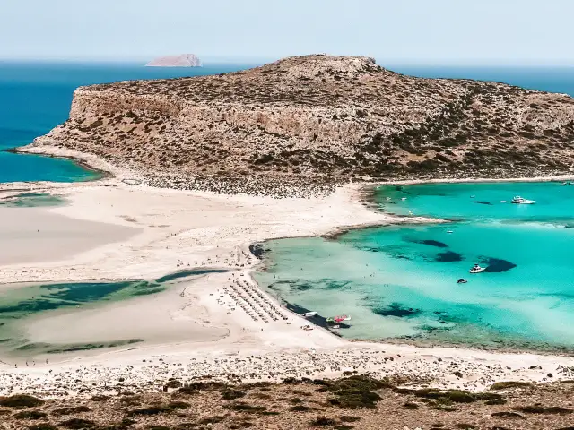 Piękna plaża na Krecie, turkusowa woda i skaliste wzgórza. Czy jest bezpiecznie? Tak, wygląda na spokojny dzień na wakacjach.
