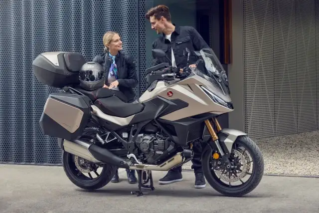 Para zwiedzająca motocykle z automatyczną skrzynią biegów. Nowoczesny turystyczny motocykl Honda z kuframi.