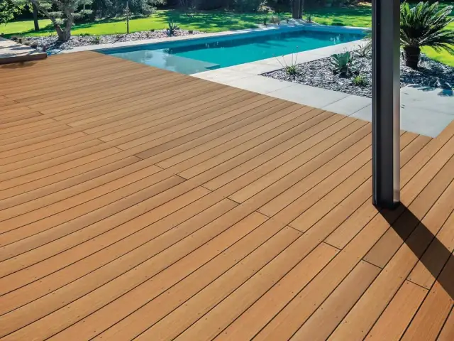 Piękny drewniany taras przy basenie. Zastanawiasz się, ile kosztuje taras drewniany? To inwestycja w komfort i styl.