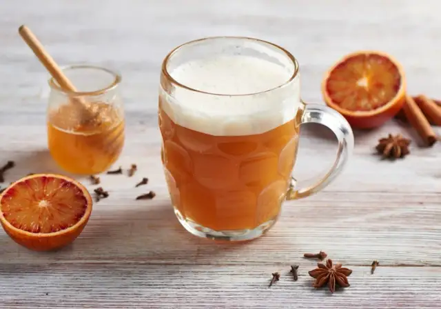 Kubek piwnego grzańca z miodem, pomarańczą i przyprawami.