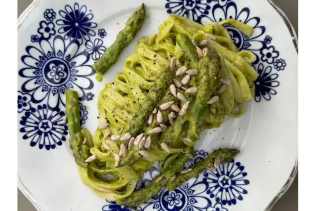 Makaron z zielonym pesto i szparagami, posypany pestkami słonecznika. Czy makaron jest zdrowy? Zależy od dodatków!