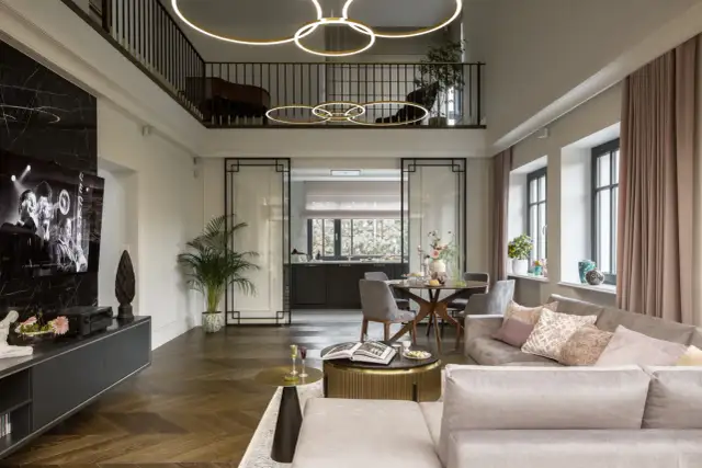 Elegancki dom art deco z dwupoziomowym salonem, nowoczesnym aneksem kuchennym i stylowymi meblami.