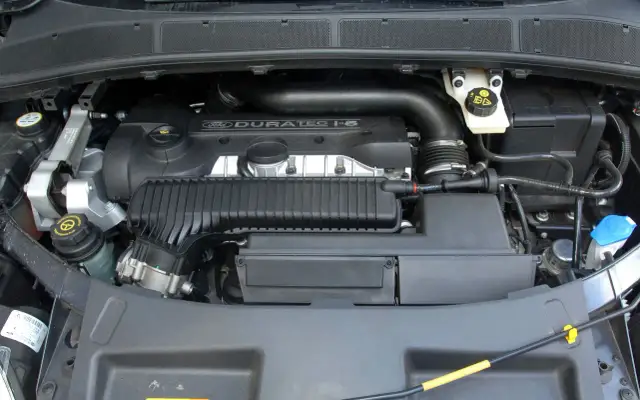 Silnik Duratec 1.5 w Fordzie Galaxy. Widoczne elementy układu dolotowego, zbiorniczek płynu wspomagania i inne podzespoły.