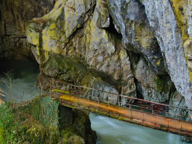 Most zwodzony nad rwącą rzeką w skalistym wąwozie, przypominającym wejście do jaskini szkockiej.