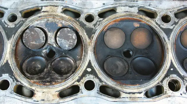 Widok głowicy silnika z widocznymi śladami zużycia. Wypalony zawór może oznaczać problemy z kompresją.