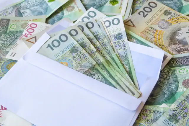 Koperta z banknotami 100 zł. Zastanawiasz się, ile dać koledze na 18 urodziny? Może ta kwota będzie inspiracją.