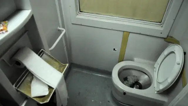 W pociągu toaleta jest w tym małym pomieszczeniu z muszlą klozetową i rolką papieru.