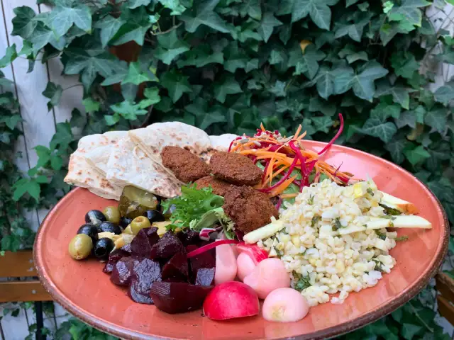 Talerz z falafelami, pitą, buraczkami, oliwkami, sałatką i kaszą.