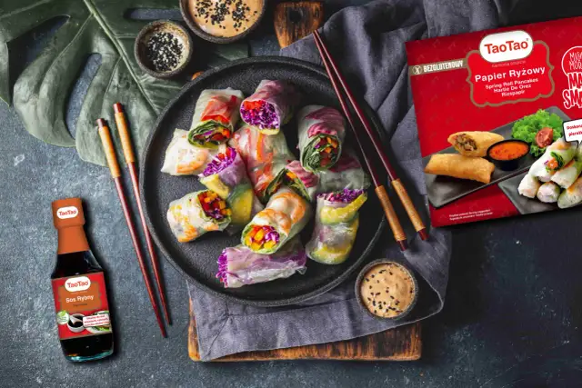 Kolorowe sajgonki składające się z krewetek, warzyw i papieru ryżowego, podane z sosem.