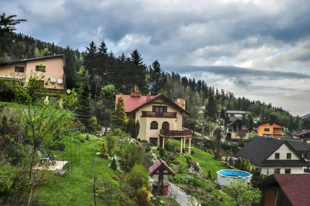 Willa Wierchy Szczyrk, malowniczo położona na zboczu, otoczona zielenią i innymi domami.