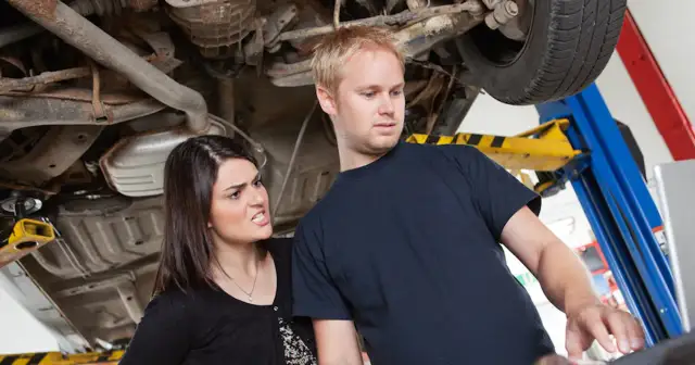 Zirytowana klientka pyta mechanika o ukryte przyczyny dla których każe płacić za diagnostykę komputerową dwa razy.