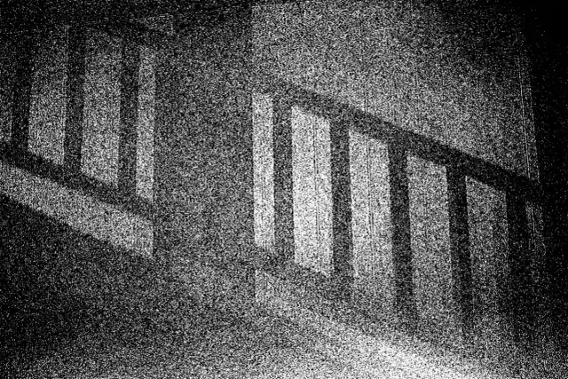 Ciemne pionowe słupki balustrady rzucają cienie, tworząc wrażenie optycznego śniegu na tle.