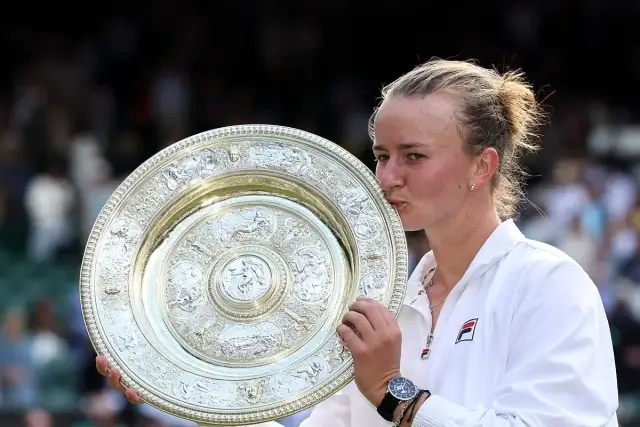 Tenisistka całuje puchar Wimbledonu.