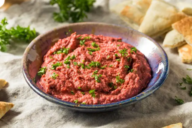 Pyszna pasta z czerwonej fasoli, posypana natką pietruszki, podana z kawałkami pity.