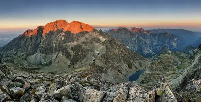 Zachód słońca nad Tatrami. Widok z polski na oświetlone zbocza Gerlacha, skaliste szczyty i górskie jeziora.
