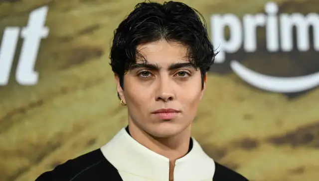 Xelia Mendes Jones z zielonymi oczami i złotą kolczykiem, na tle logo Amazon Prime.