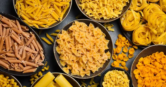 Różne rodzaje makaronu, od penne po farfalle, gotowe do przyrządzenia al dente. Idealne do każdej potrawy.