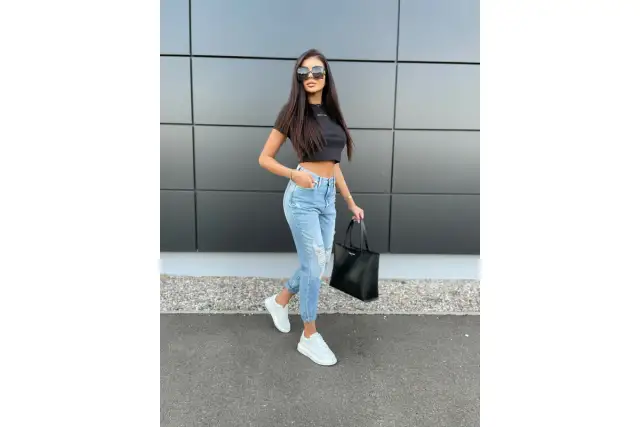 Krótki czarny top i podarte jeansy to świetny przykład, jak łączyć ubrania w zestawy. Dodaj białe sneakersy i czarną torbę.