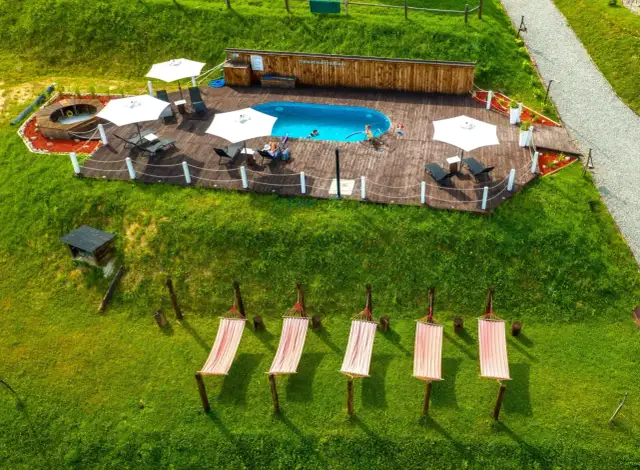 Basen, leżaki i hamaki na trawie w Bieszczadach.