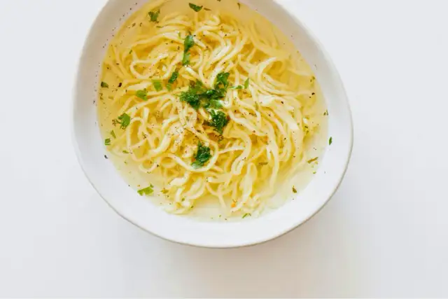 Miseczka z bulionem i makaronem, posypana natką. Czy maggi jest zdrowe? To pytanie nurtuje wielu.