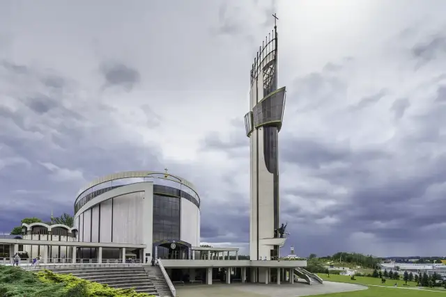 Nowoczesne Sanktuarium Miłosierdzia Bożego z charakterystyczną wieżą i okrągłym budynkiem.