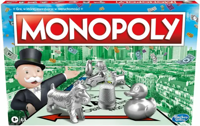 Pudełko gry Monopoly z Mr. Monopoly, pionkami i pieniędzmi na tle miasta.