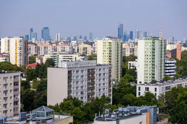 Widok na osiedle mieszkaniowe z blokami i wieżowcami w tle. Zastanawiasz się, jak ubezpieczyć mieszkanie?