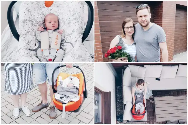 Szczęśliwy wyjście ze szpitala z noworodkiem. Rodzice z bukietem róż i maleństwem w foteliku samochodowym.