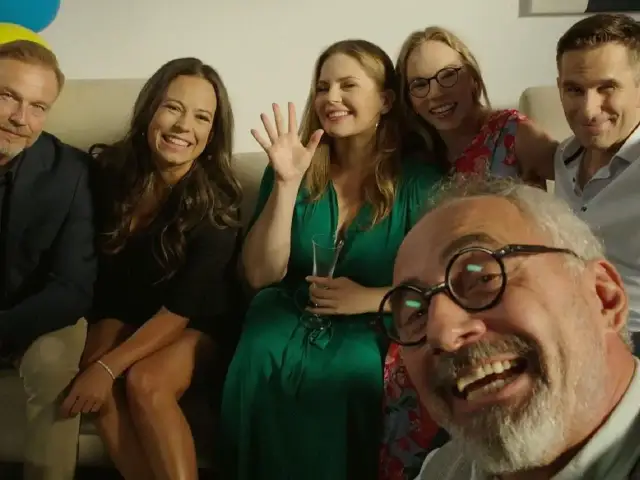 Uśmiechnięci aktorzy, którzy grali w M jak Miłość, pozują do zdjęcia. Widać ich od pasa w górę, siedzą na kanapie.