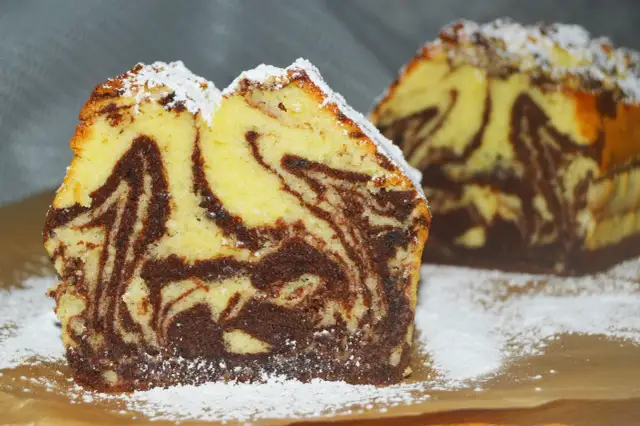 Wilgotna babka marmurkowa na oleju, oprószona cukrem pudrem. Jej puszyste ciasto z kontrastowymi pasmami czekolady zachęca do spróbowania.