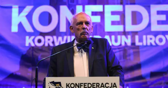 Mężczyzna w garniturze i muszce przemawia na tle napisu "KONFEDERACJA".