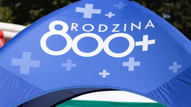 Niebieski namiot z białym napisem "RODZINA 800+" i symbolami krzyżyków.